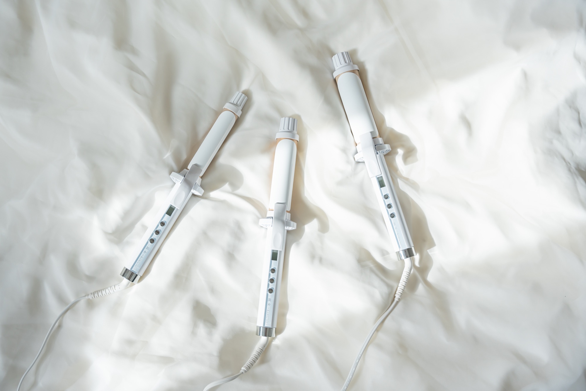 KINUJO Curling Iron lineup on silk sheets